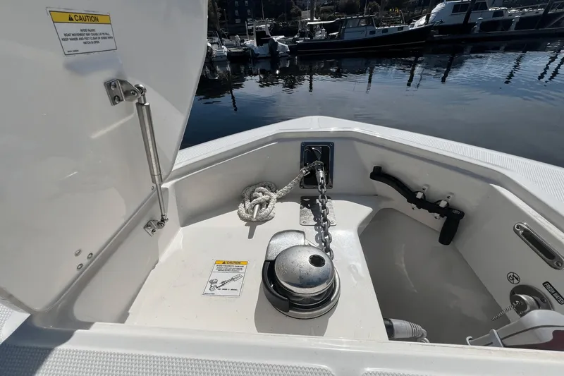  Yacht Photos Pics 2024 Boston Whaler 280 Outrage anchor compartment with chain and rope, docked at marina.