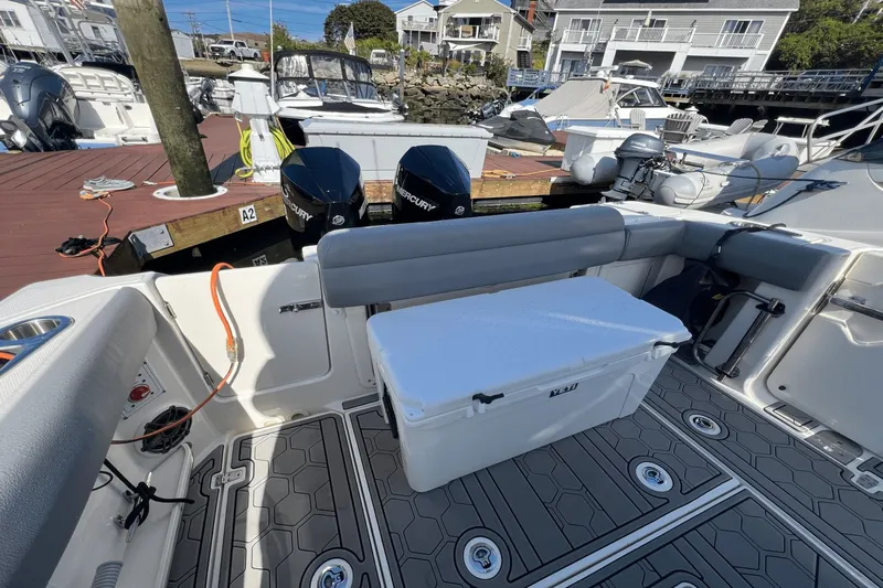  Yacht Photos Pics 2024 Boston Whaler 280 Outrage boat interior with seating and cooler, docked at marina.