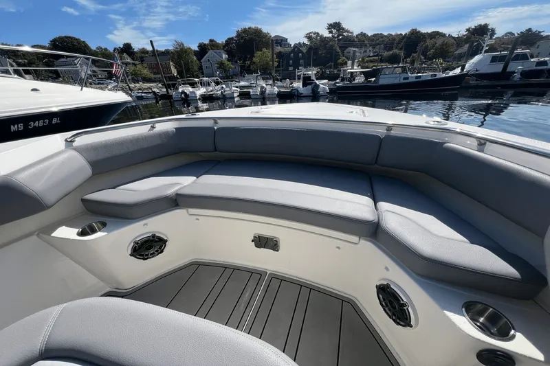  Yacht Photos Pics 2024 Boston Whaler 280 Outrage boat interior with cushioned seating and cup holders in a marina.