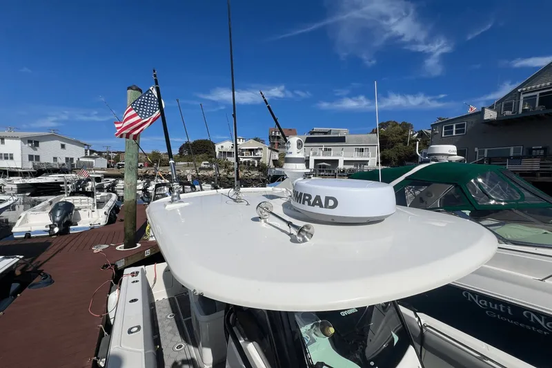  Yacht Photos Pics 2024 Boston Whaler 280 Outrage docked, featuring radar equipment and American flag.