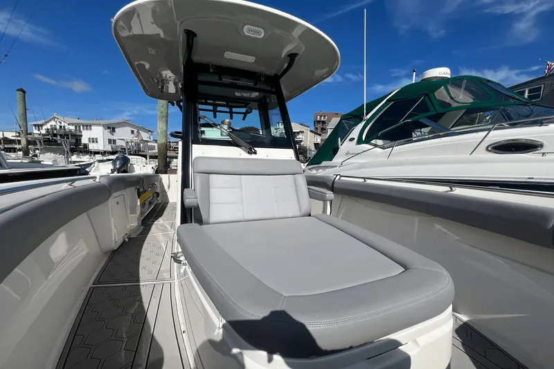  Yacht Photos Pics 2024 Boston Whaler 280 Outrage boat with sleek seating and modern design at a marina.