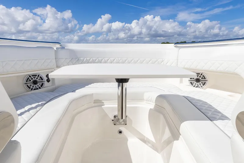  Yacht Photos Pics Manufacturer Provided Image: 2025 Pursuit DC 306 Dual Console boat interior with white seating and table under blue sky.
