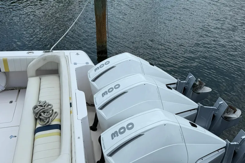  Yacht Photos Pics 2006 Intrepid 377 boat with triple outboard engines docked by the water.