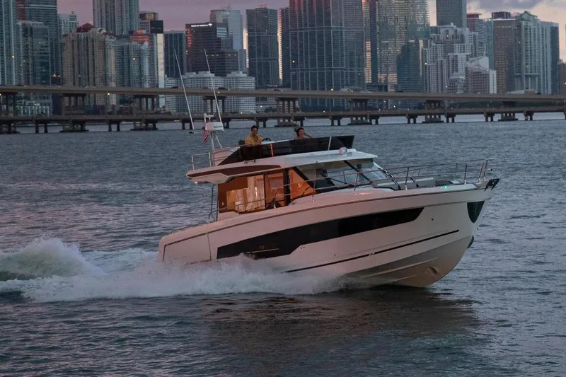  Yacht Photos Pics Manufacturer Provided Image: 2025 Jeanneau NC 1295 Fly cruising near city skyline at dusk.