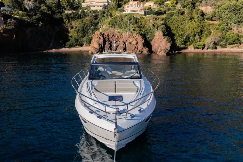 V50 Open Yacht Photos Pics 2026 Princess V50 Open yacht on serene water near rocky coastline.