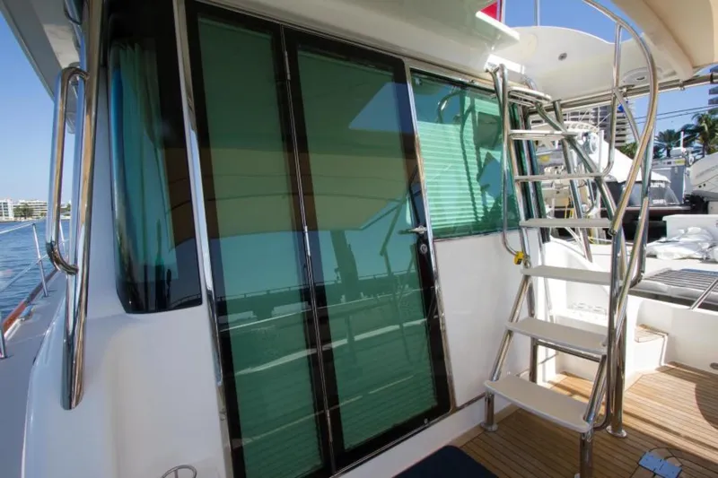 Ohana Yacht Photos Pics 2016 Sabre Flybridge yacht with glass doors and metal staircase on deck.