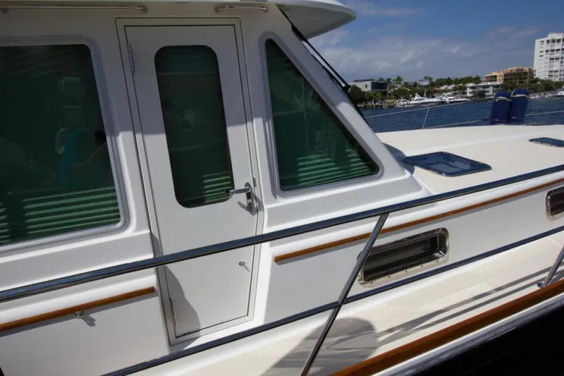 Ohana Yacht Photos Pics 2016 Sabre Flybridge yacht side view with door and windows, docked by the water.