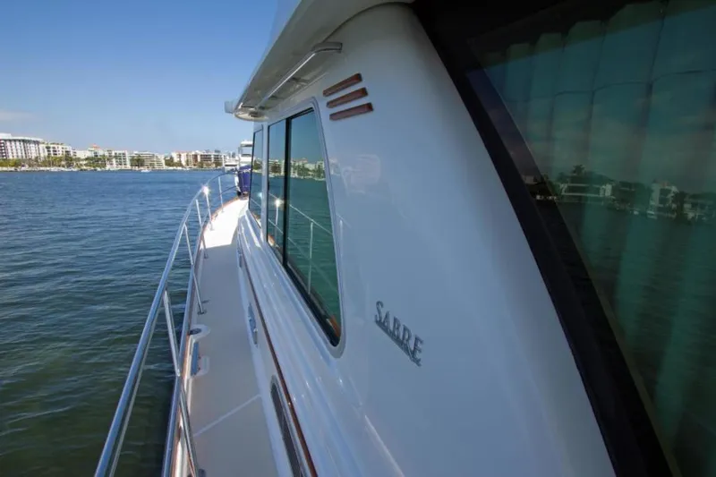 Ohana Yacht Photos Pics 2016 Sabre Flybridge yacht cruising on a sunny day near the coastline.