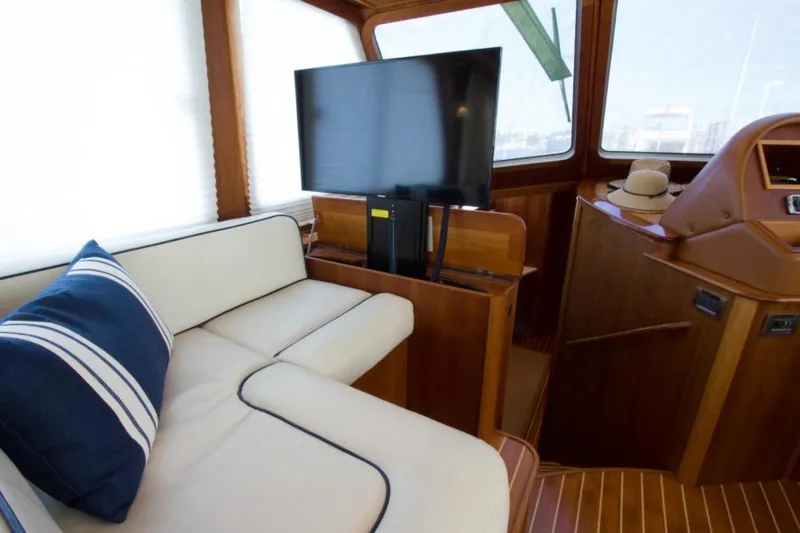 Ohana Yacht Photos Pics Luxurious 2016 Sabre Flybridge interior with TV, white seating, and nautical decor.