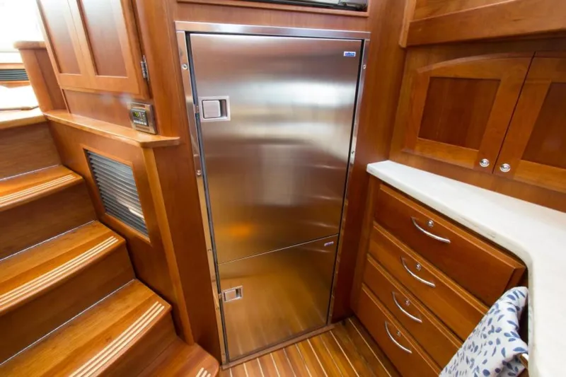 Ohana Yacht Photos Pics Luxurious 2016 Sabre Flybridge yacht interior with stainless steel fridge and wooden cabinetry.
