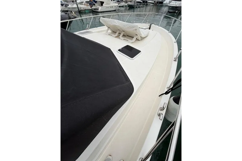  Yacht Photos Pics 2023 Maritimo M600 yacht deck with black cover and marina view.