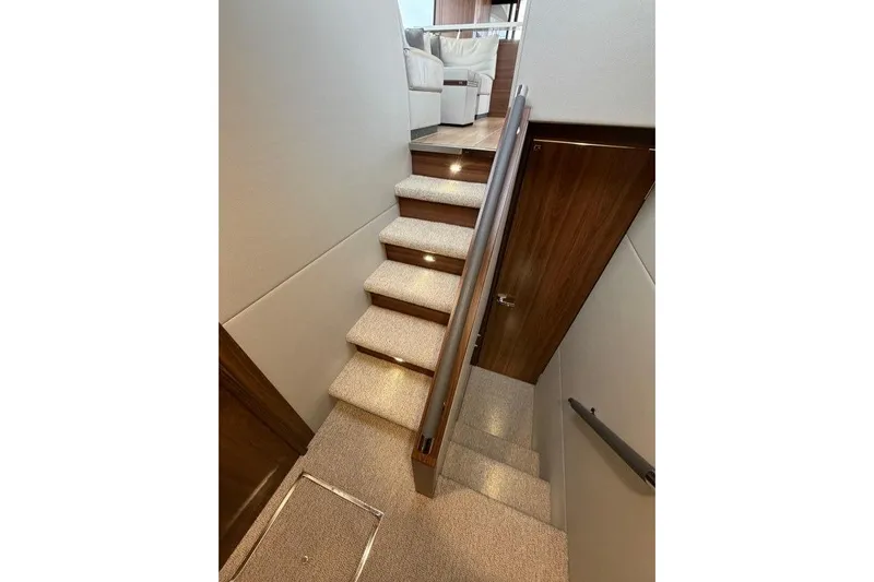 Yacht Photos Pics Staircase in 2023 Maritimo M600 yacht, featuring carpeted steps and wooden handrails.
