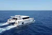 Ocean Beast 65 catamaran cruising on open sea, 2020 model, clear blue sky.