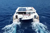 Catamaran Ocean Beast 65 cruising on open sea, rear view, 2020 model.