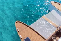 Catamaran Ocean Beast 65 (2020) on clear turquoise water, featuring wooden deck and netting.