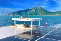 Catamaran Ocean Beast 65 with solar panels, cruising near scenic island, 2020 model.