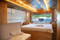 Luxurious bedroom interior of 2020 Catamaran Ocean Beast 65 with scenic window view.