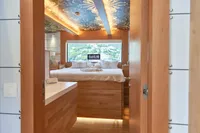 Luxurious bedroom interior on 2020 Catamaran Ocean Beast 65 with scenic window view.