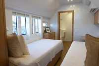 Luxurious bedroom on 2020 Catamaran Ocean Beast 65 with twin beds and ocean view.