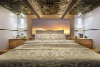 Luxurious bedroom interior of 2020 Catamaran Ocean Beast 65 with elegant bedding and ambient lighting.