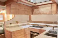 Modern kitchen interior on 2020 Catamaran Ocean Beast 65, featuring sleek wood cabinetry and countertops.