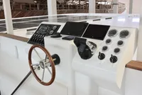 Helm of 2020 Catamaran Ocean Beast 65 with modern controls and wooden steering wheel.
