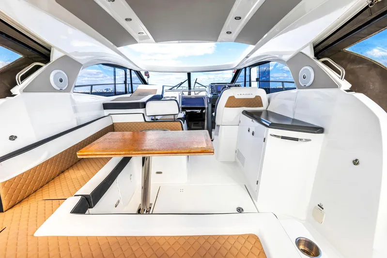  Yacht Photos Pics 2018 Jeanneau Leader 36 interior with seating, table, and helm, showcasing luxury yacht design.