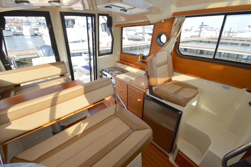 Chestnuts Yacht Photos Pics Interior of 2020 Ranger Tugs R-27 boat with seating, kitchenette, and marina view.