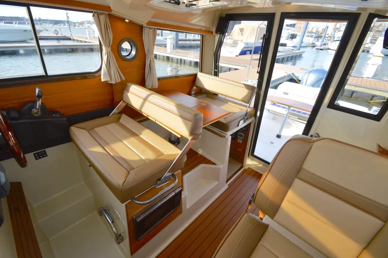 Chestnuts Yacht Photos Pics Interior of 2020 Ranger Tugs R-27 boat with tan seating and wood accents at a marina.