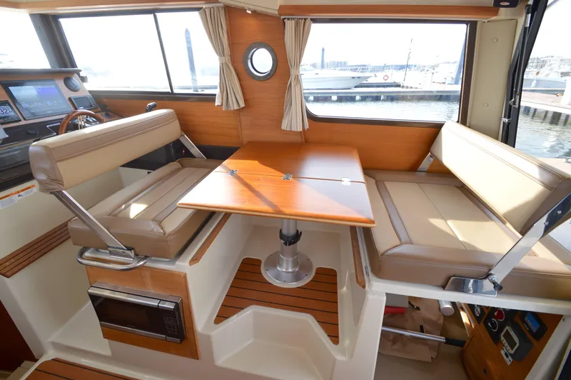 Chestnuts Yacht Photos Pics Interior of 2020 Ranger Tugs R-27, featuring a cozy dining area with beige seating.