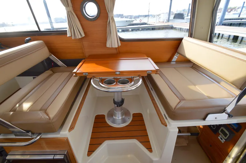 Chestnuts Yacht Photos Pics Interior of 2020 Ranger Tugs R-27 with beige seating and wooden table.
