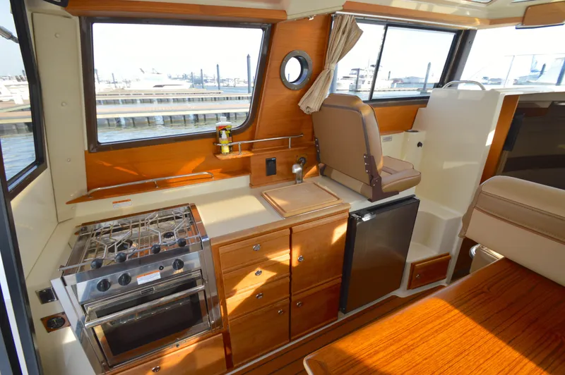 Chestnuts Yacht Photos Pics Interior of 2020 Ranger Tugs R-27 with kitchen, stove, and seating area.