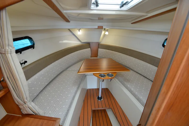 Chestnuts Yacht Photos Pics 2020 Ranger Tugs R-27 cabin interior with wood table and cushioned seating.
