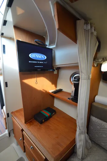 Chestnuts Yacht Photos Pics 2020 Ranger Tugs R-27 interior with TV, wooden cabinetry, and cozy seating area.