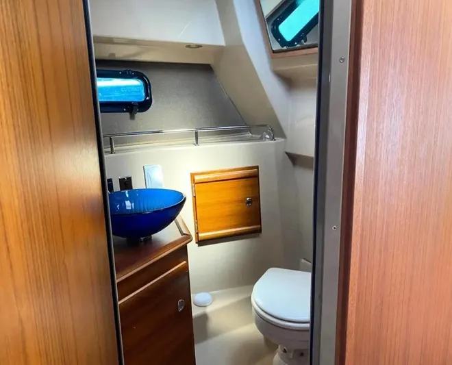 Chestnuts Yacht Photos Pics 2020 Ranger Tugs R-27 boat bathroom with blue sink and wooden cabinetry.