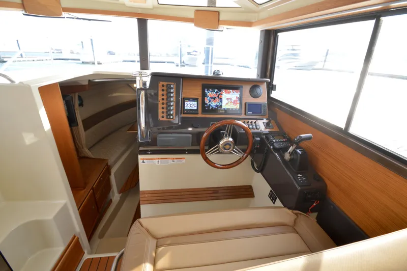 Chestnuts Yacht Photos Pics 2020 Ranger Tugs R-27 boat interior with helm, navigation controls, and seating.