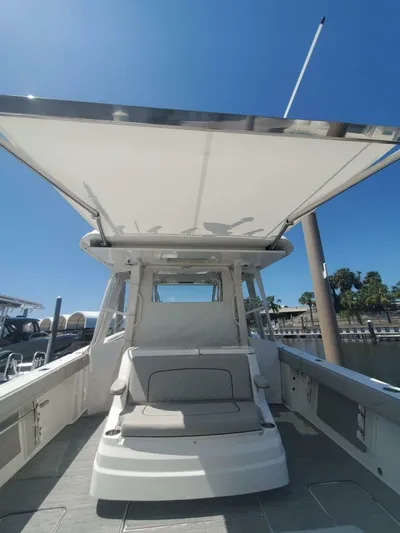 Fiji Kai Yacht Photos Pics 2023 Pursuit S378 boat with canopy, docked under clear blue sky.