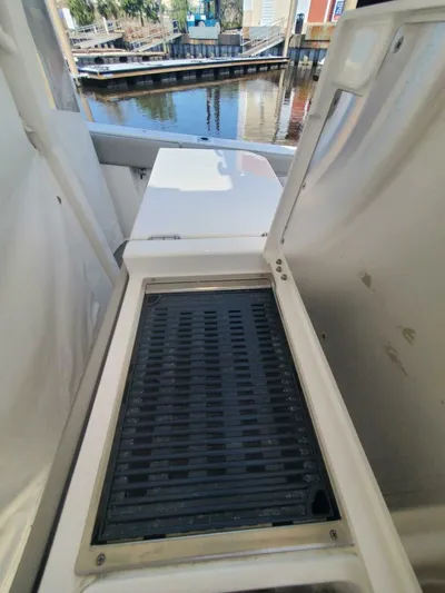 Fiji Kai Yacht Photos Pics 2023 Pursuit S378 boat interior with open storage compartment near a marina.