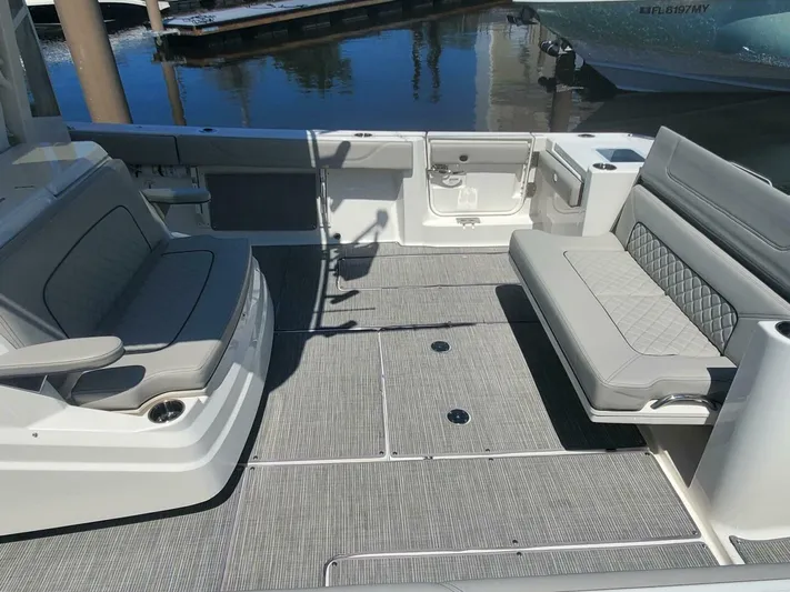 Fiji Kai Yacht Photos Pics 2023 Pursuit S378 boat interior with gray seating and deck, docked by the water.