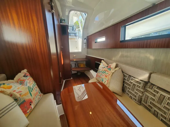 Fiji Kai Yacht Photos Pics Luxurious interior of 2023 Pursuit S378 boat with wooden table and comfortable seating.