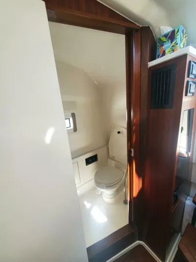 Fiji Kai Yacht Photos Pics 2023 Pursuit S378 boat interior bathroom with wooden accents and modern fixtures.