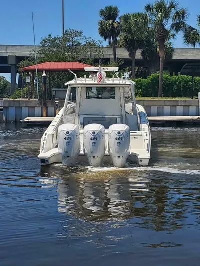Fiji Kai Yacht Photos Pics 2023 Pursuit S378 boat with triple engines on a sunny day near a dock.