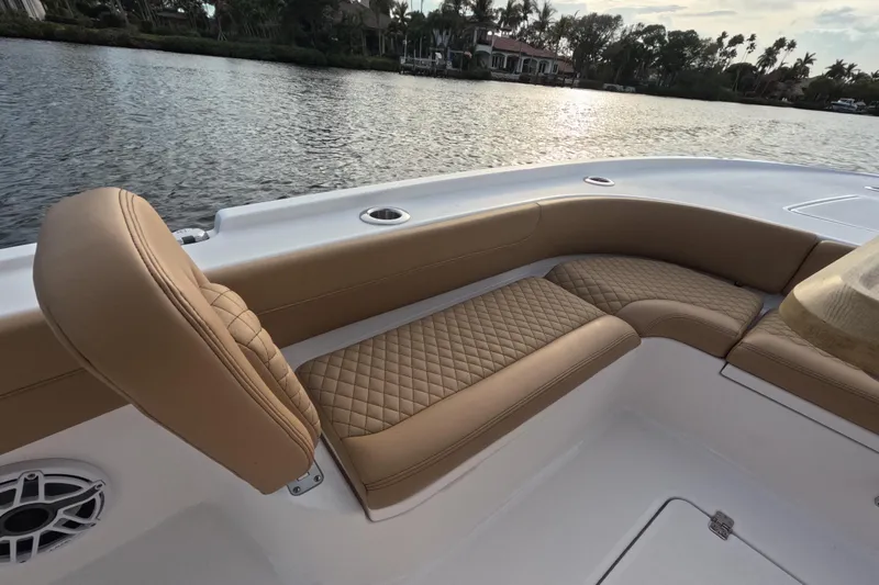  Yacht Photos Pics Luxurious seating on 2024 Caymas 281 HB boat, featuring tan quilted upholstery by the water.