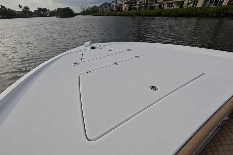  Yacht Photos Pics 2024 Caymas 281 HB boat deck on calm waterway, surrounded by lush greenery.