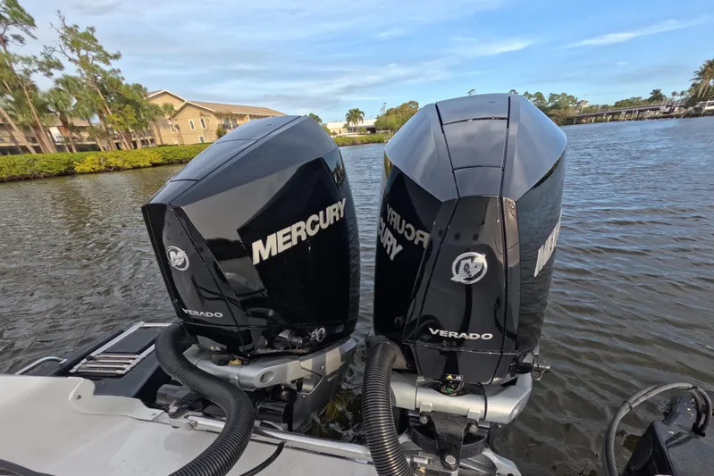  Yacht Photos Pics Twin Mercury Verado engines on 2024 Caymas 281 HB boat, docked on a scenic waterway.