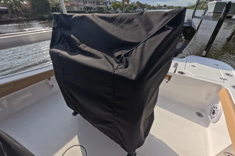  Yacht Photos Pics 2024 Caymas 281 HB boat with covered console, docked by waterfront homes.