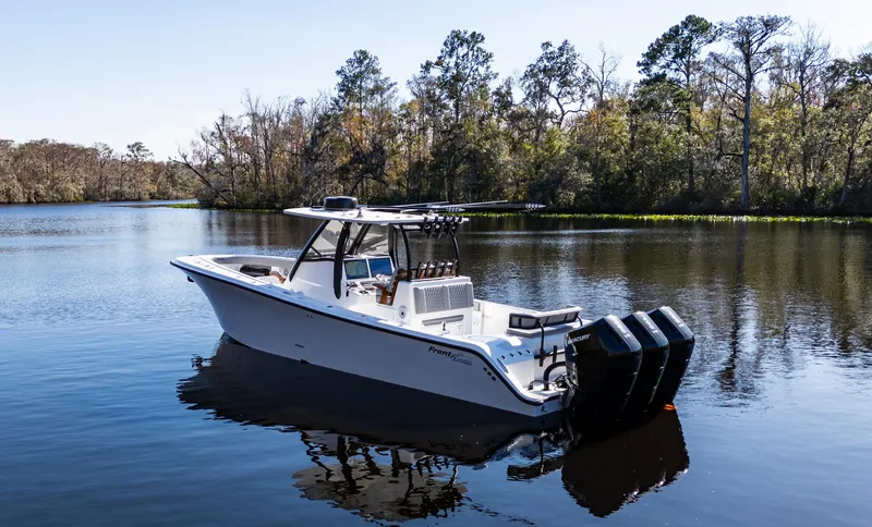  Yacht Photos Pics 2026 Front Runner 36 Center Console boat on a serene lake with forest backdrop.