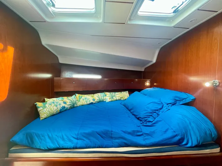 Caravan Yacht Photos Pics Cozy cabin interior of 2002 Beneteau First 47.7 sailboat with blue bedding.