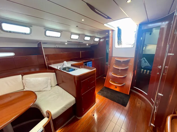 Caravan Yacht Photos Pics Luxurious interior of 2002 Beneteau First 47.7 yacht with wood finish and modern amenities.