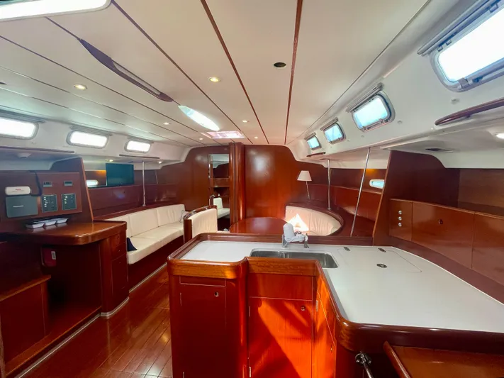 Caravan Yacht Photos Pics Luxurious interior of 2002 Beneteau First 47.7 yacht with elegant wood finish and modern amenities.